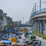 bustling street with elevated metro in delhi